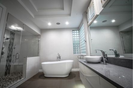 Detail of pebble tile shower flooring and mosaic columns in a luxury Westlake Village bathroom remodel by Drywall Repair & Remodeling.