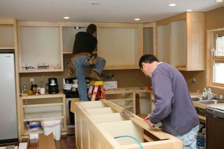 Kitchen remodeling underway in Thousand Oaks with new custom cabinets being installed by two professional contractors.