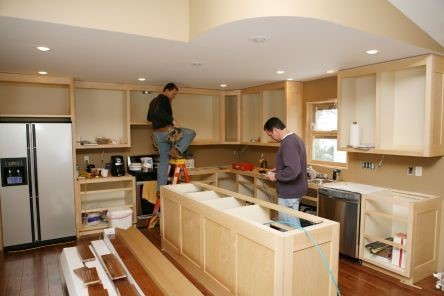 Kitchen remodeling underway in Thousand Oaks with new custom cabinets being installed by two professional contractors.
