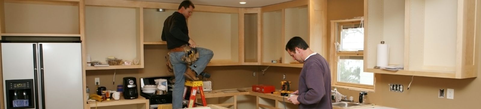 Kitchen remodeling underway in Thousand Oaks with new custom cabinets being installed by two professional contractors.
